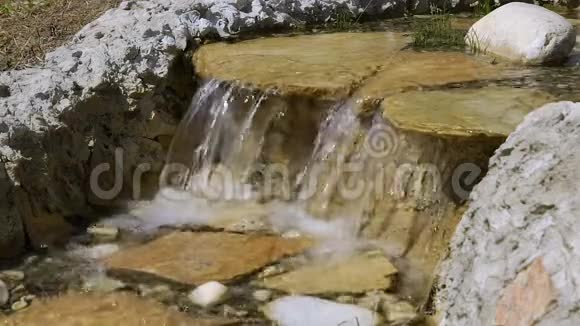 公园里的装饰一个小瀑布慢动作的水从岩石中掉下来视频的预览图