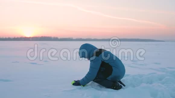 日落时一个孩子在雪地里翻筋斗新鲜空气中的乐趣和游戏视频的预览图