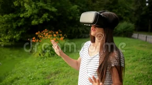 城市公园的湖畔矗立着一幅可爱的小女孩虚拟现实眼镜的画像运动效应视频的预览图