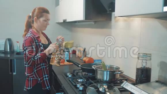 女人在厨房做饭的概念女孩把葵花籽油倒在格栅上女孩妈妈在厨房在室内准备视频的预览图