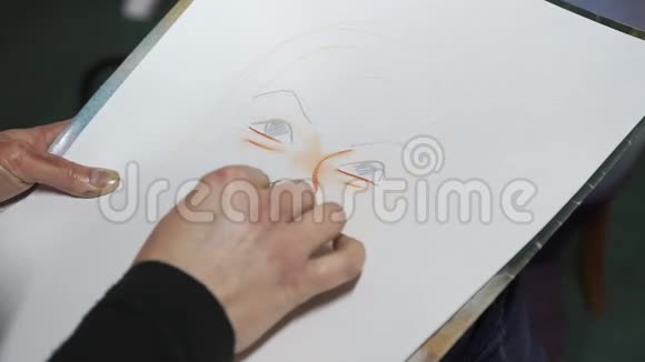 一个女人在纸上画了一幅粉笔的卡通画像特写只有手怪诞的模仿的视频的预览图