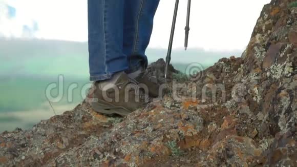 旅行者的女人用棍子爬上山坡进行追踪双腿合拢慢镜头视频的预览图