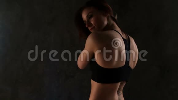 适合在黑暗背景下准备训练的女性女子在健身房锻炼前把头发扎成一束视频的预览图
