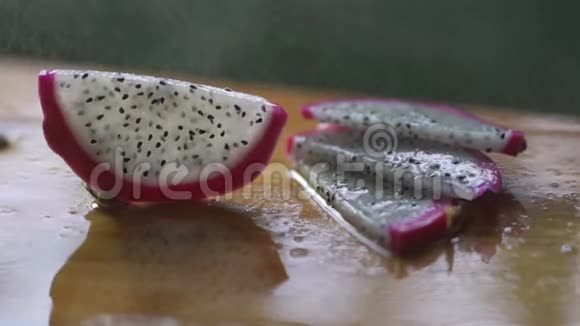 龙果切在木桌上水滴落在火龙果上视频的预览图