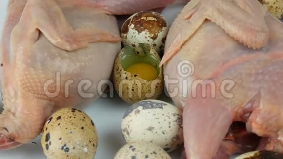 白色背景鹌鹑蛋旁边的塑料棕色托盘中鹌鹑的新鲜肉旋转视频的预览图
