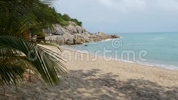 热带天堂异国情调的白沙滩被蓝色平静的大海冲刷阴云密布的沙滩上绿油油的椰棕视频的预览图
