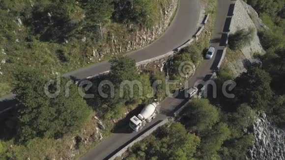 骑着摩托车和一辆汽车在华丽茂盛的森林山坡上驰骋穿过起伏的道路视频的预览图