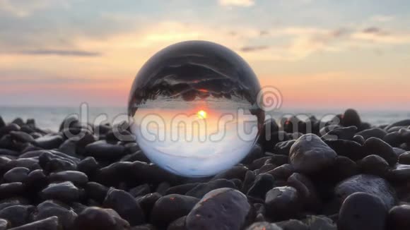 美丽的夕阳倒映在石头上的水晶球里阳光洒在水面上沙滩上风景如画视频的预览图