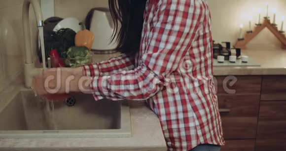 特写一个女人在厨房的水槽里洗蔬菜视频的预览图