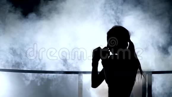 女孩年轻的女人做影子拳击跆拳道烟雾中的轮廓视频的预览图