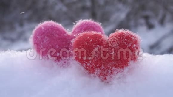 冬天河滨白雪上红粉色的毛心视频的预览图