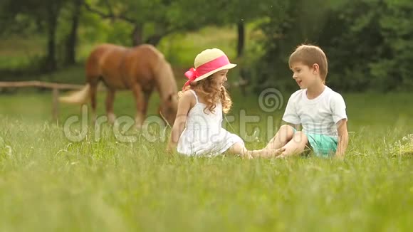 孩子们坐在公园的草坪上他们说话很愉快玩得很开心慢动作视频的预览图