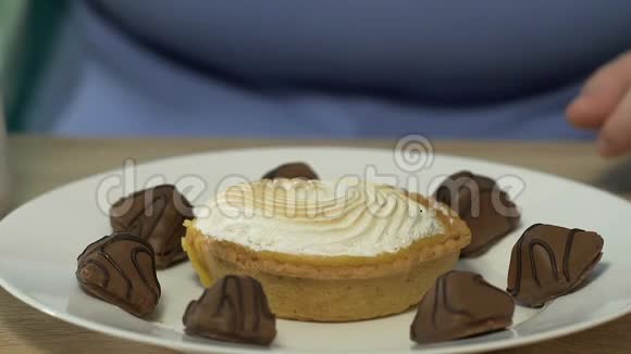 一位肥胖的女性用大量的糖果和巧克力用焦糖装饰视频的预览图