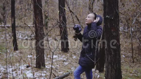 活跃的健康白人妇女带着一个背包在森林湖上用老式的胶卷相机拍照视频的预览图