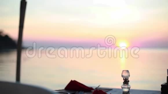 在海滩上吃饭日落时海边海滩餐厅的一张桌子1920x1080视频的预览图