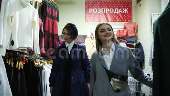 两个活泼开朗的年轻女子正在穿过一家服装店视频的预览图