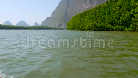 这块巨大的陡峭的岩石耸立在雨林之上从长尾船上看风景视频的预览图