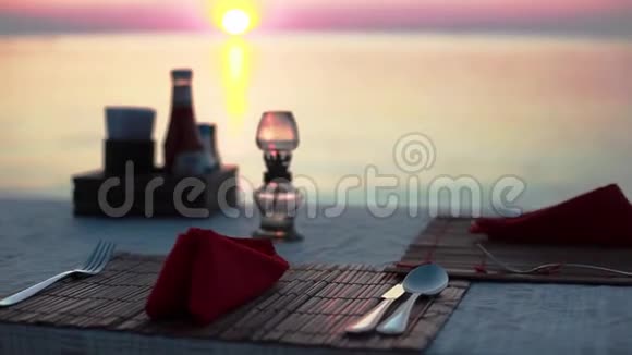 在海滩上用餐日落时分海景边的一家海滩餐馆里摆着餐具的桌子1920x1080个视频的预览图