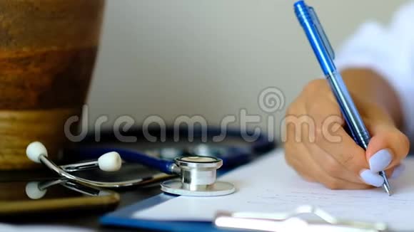 年轻的治疗师坐在办公桌前填写医疗清单保健和保险理念女医生视频的预览图