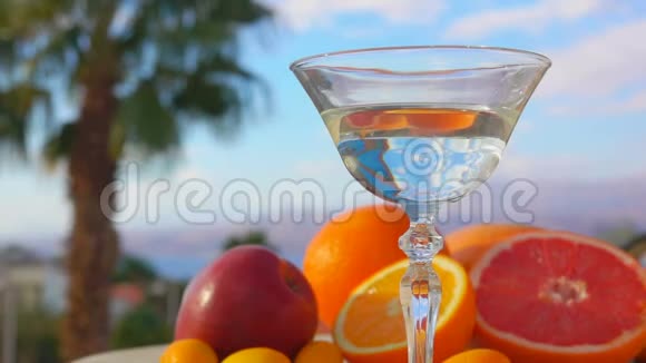 在柑橘类水果的背景下橄榄掉进了一杯马丁尼酒视频的预览图