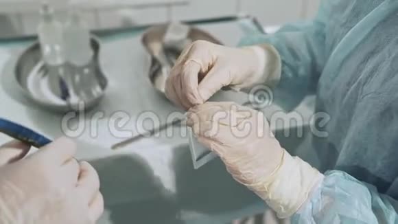 带无菌医疗器械的手术台助手给外科医生手术刀特写镜头视频的预览图