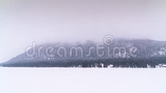 冬天湖中的山消失在雾中视频的预览图