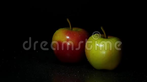 黑暗背景上的两个苹果一滴水顺着苹果流下视频的预览图