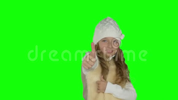 穿白色针织帽子的年轻女孩展示手势胜利标志和竖起大拇指的手势年轻女孩的手势新年视频的预览图