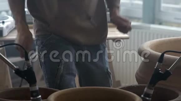 临时音乐家在陶工坊大陶罐上演奏木棍视频的预览图