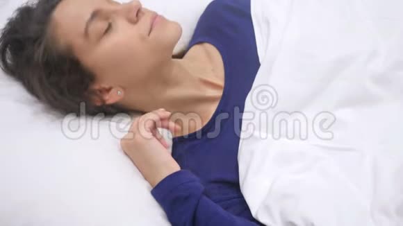 头痛不舒服的西班牙女人从睡梦中醒来视频的预览图