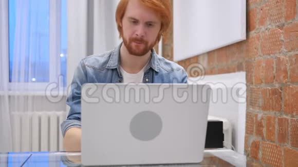 思考头脑风暴悲伤的红发胡子人在工作视频的预览图