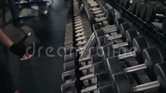强壮的男人的手拿着一个沉重的哑铃在健身房近距离宏观室内运动的家伙视频的预览图