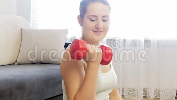 4k特写镜头年轻的微笑女性用哑铃锻炼和锻炼手部肌肉视频的预览图