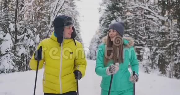 在树林里滑雪的冬天有爱心的男女慢动作情人节视频的预览图