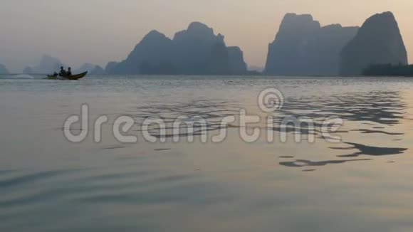 船沿着平静的水面游泳山后日落视频的预览图