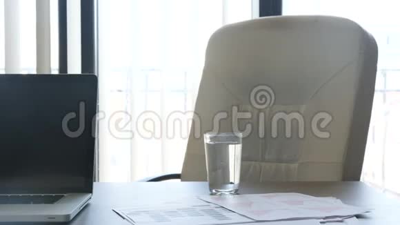 办公室窗户前桌子上的现代笔记本电脑视频的预览图