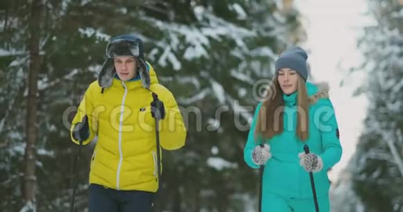 在树林里滑雪的冬天有爱心的男女慢动作情人节视频的预览图