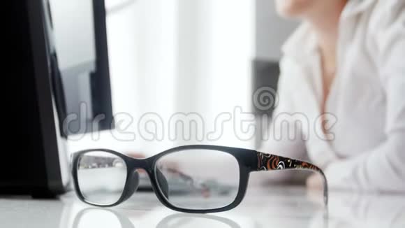 特写4k视频的年轻妇女在办公室工作将眼镜放在办公桌上视频的预览图