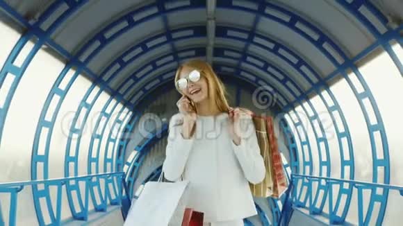一个时髦的女人带着购物袋在电话里说话成功的购物理念视频的预览图