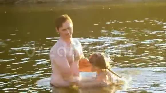 一个十几岁的女孩和父亲一起在凉爽的河流里洗澡视频的预览图