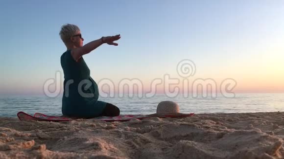 怀孕九个月的妇女在海滩上锻炼视频的预览图