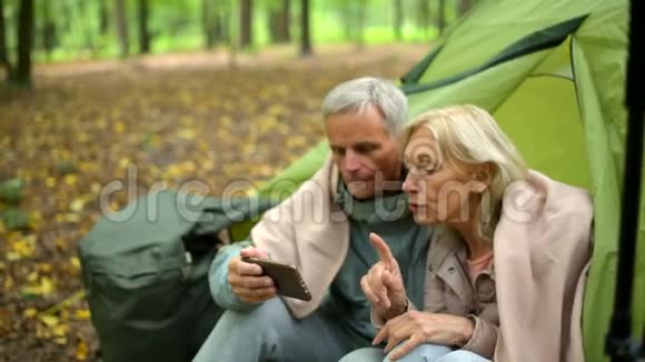 一对在森林里使用导航仪的快乐老夫妇视频的预览图