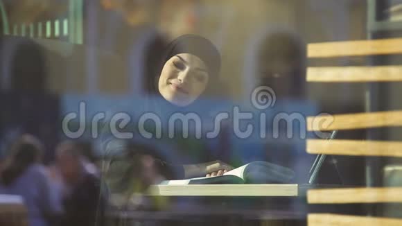 咖啡馆里传统阿拉伯服装读本中颇具魅力的女学生视频的预览图