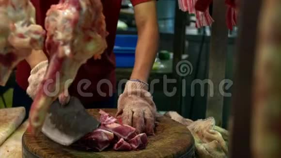 摆摊商用刀在木板上切块猪肉的慢动作视频的预览图