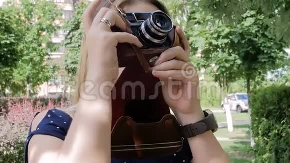在公园用旧的手动摄像机拍摄的年轻女子的慢镜头视频的预览图