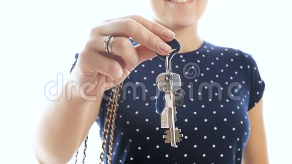4k特写镜头年轻微笑女子在白色背景下拿着家钥匙视频的预览图