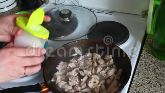 一个男人把肉炸成肉酱把它放入煎锅中用勺子拌匀视频的预览图
