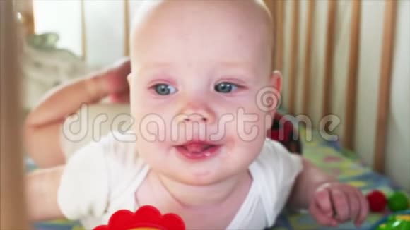 一张漂亮蓝眼睛6个月小男孩看着某人的慢镜头画像视频的预览图