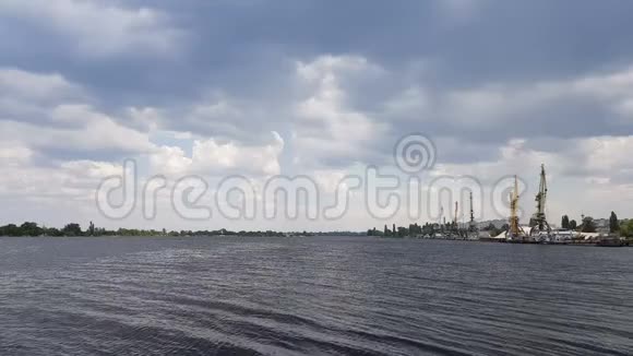 多云的天空和河流中的城市景观和天际线阳光蓝天丹妮珀河港口的集装箱起重机装卸视频的预览图
