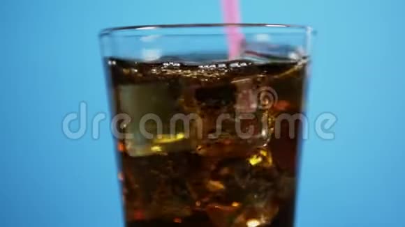 把可乐鸡尾酒和饮料吸管混合盛满泡沫饮料冰块的玻璃杯视频的预览图